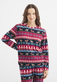 Camiseta de pijama de manga larga en rojo y azul marino con un patrón de árboles decorados, copos de nieve y dachshunds en suéteres festivos. Textura de tela suave.