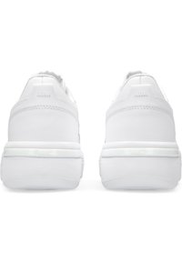 Sneakers bianchi con tomaia in pelle liscia, punta arrotondata e suola bianca imbottita. Presenta un tallone textured e un logo del marchio visibile.