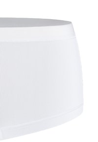Boxer corto elasticizzato bianco con texture a coste, cintura liscia con logo del marchio e bordi puliti senza cuciture visibili.