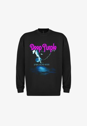 Sort sweatshirt med et grafisk design, der har teksten "Deep Purple" i pink og "Smoke on the Water" nedenunder, sammen med blåt vand og skyer.