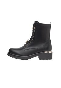 Bottine en cuir noire avec lacets à l'avant et œillets dorés. Talon épais avec accent argenté. Texture lisse avec bout arrondi.