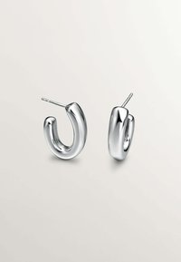 Par de pendientes de aro de plata con una superficie pulida y suave. El diseño presenta una forma redondeada en U con un poste delgado para el cierre.