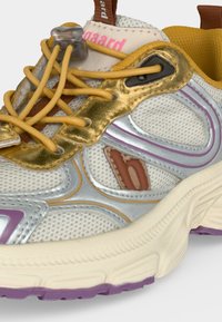 Baskets de couleur claire avec des accents métalliques dorés, des lacets jaunes avec un verrou, un tissu en mesh et des détails violets et argentés sur la semelle et le côté.