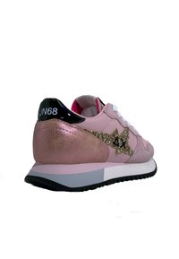 Scarpa sportiva rosa con tomaia in suede, dettaglio a stella glitterato, accentuazione nera sul tallone e lacci bianchi. Presenta una suola imbottita e una forma arrotondata.