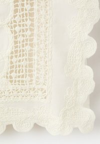 White fabric square with intricate lace trim and central rectangular openwork pattern featuring small floral motifs.