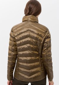 Olivgrön, vadderad jacka med hög krage, med chevron-sömnad och en slät, glansig tygstruktur.