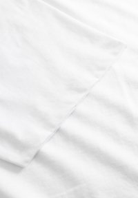 Hvid bomuldsstof med en glat tekstur, der har en enkel opsømmet kant. Ingen synlige mønstre eller accenter.