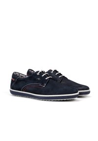 Chaussures lacées bleu marine en daim, avec des semelles en caoutchouc blanc, des accents rouges et un motif texturé subtil.