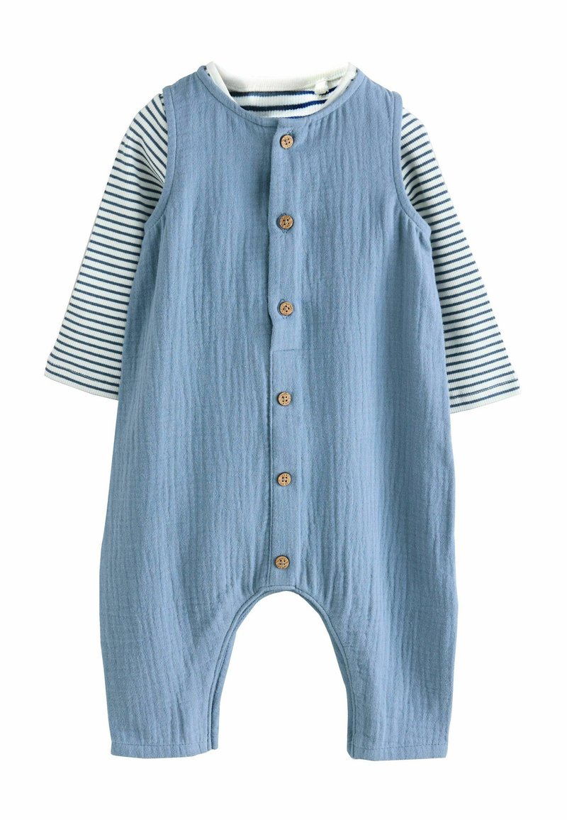 Blauer ärmelloser Spielanzug mit Holzknöpfen über einem weißen Langarmshirt mit marineblauen Querstreifen, entworfen für ein Baby oder Kleinkind.