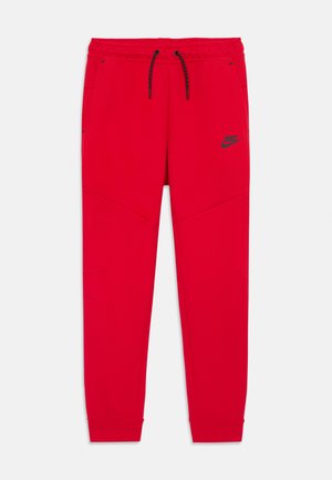 Pantaloni del sudore Nike rossi realizzati in materiale morbido, con vita regolabile con cordino, gambe affusolate e un logo nero sul lato sinistro superiore.