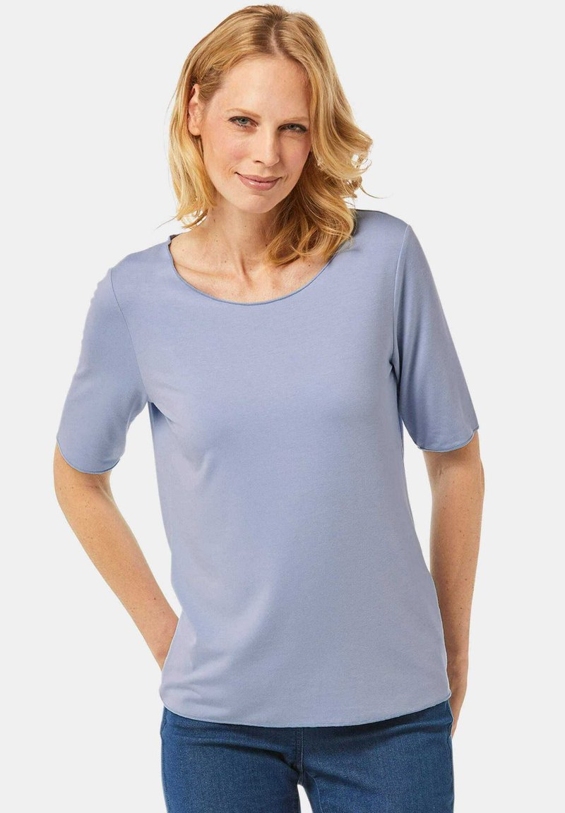 Helles blaues, kurzärmliges Oberteil mit rundem Halsausschnitt. Weicher, leichter Stoff mit lässiger Passform und dezentem Glanz. Einfaches Design, ohne Muster.