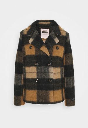 Dwurzędowy płaszcz wełniany w kratę, w odcieniach czerni, brązu i beżu. Wyróżniające szczegóły to duże guziki oraz kołnierz.