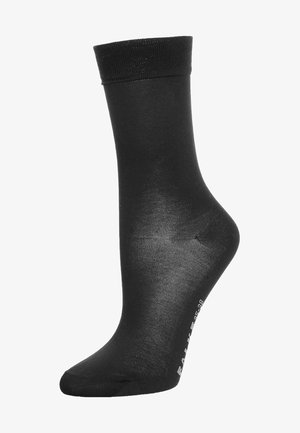 Schwarze Knöchelsocke aus einem glatten, dehnbaren Stoff mit einem gerippten Bündchen. Sie verfügt über eine passgenaue Form mit verstärktem Zehen- und Fersenbereich, gekennzeichnet mit Größenangaben.