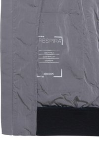 Gray waterproof jacket featuring a textured finish, with white printed labels indicating it's breathable, water-repellent, and windproof.