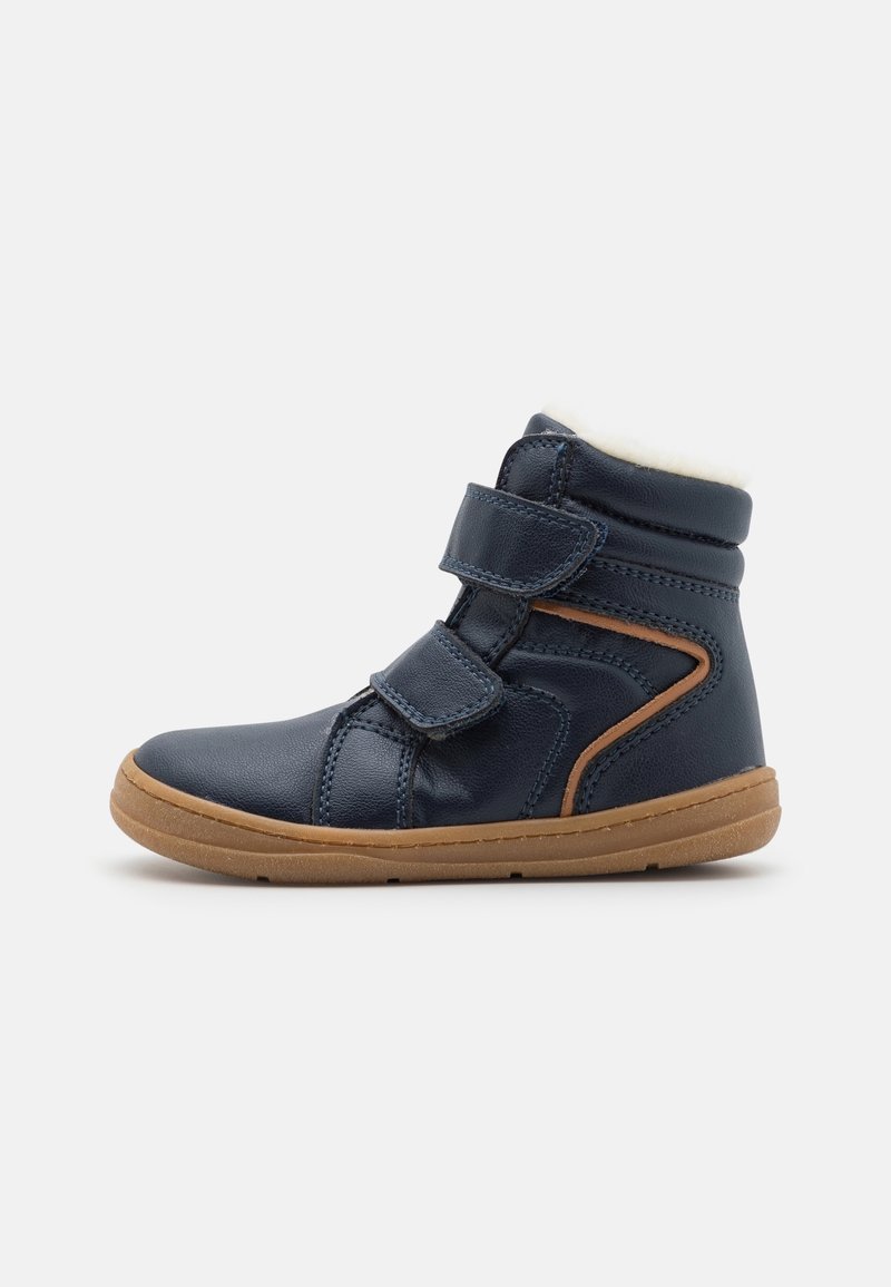 Chaussure montante pour enfant bleu marine avec semelle marron, deux bandes Velcro et couture accentuée marron clair sur le côté.
