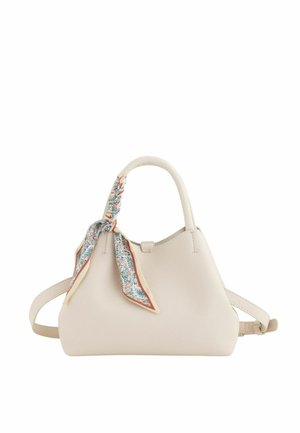 Bolso de mano de cuero crema con asa superior, correa ajustable para el hombro y pañuelo con estampado floral atado alrededor del asa.
