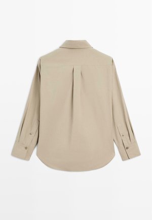 Camicia beige a maniche lunghe con colletto, dettagli con pince sul retro, polsini con bottone e orlo arrotondato. Texture del tessuto morbido e liscio.
