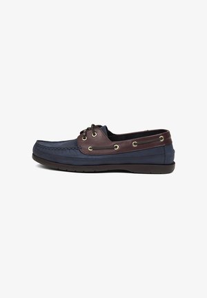 Chaussure bateau pour homme en cuir bicolore bleu marine et marron avec lacets à l'avant et bout mocassin cousu, semelle en caoutchouc plate.