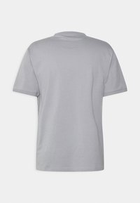 Camiseta gris de manga corta con cuello redondo, hecha de algodón, que presenta una textura suave y un diseño liso. Vista trasera mostrada.