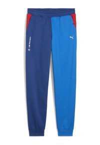 Blaue und marineblaue Jogginghose mit roten Akzenten, elastischem Bund, Seitentaschen und weißen Logo-Details am linken Bein. Weicher Baumwollmischstoff.