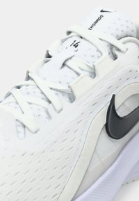 Λευκό αθλητικό παπούτσι με υφασμάτινο άνω μέρος με υφή, μαύρο λογότυπο Nike swoosh και στρογγυλή μύτη. Διαθέτει κανονικό δέσιμο και έντονα λογοτεχνικά χαρακτηριστικά στο πέλμα.