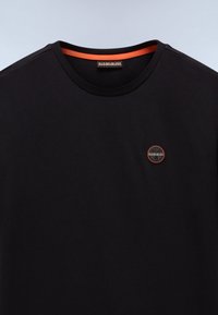 Sort t-shirt med rund halsudskæring med orange kant indvendig i kraven og lille rund logo-patch på venstre bryst.