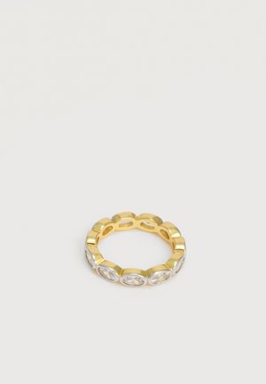 Zelta gredzens ar vairākiem ovālas formas caurspīdīgiem dārgakmeņiem, kas vienmērīgi izvietoti ap joslu uz vienkārša gaiša fona.