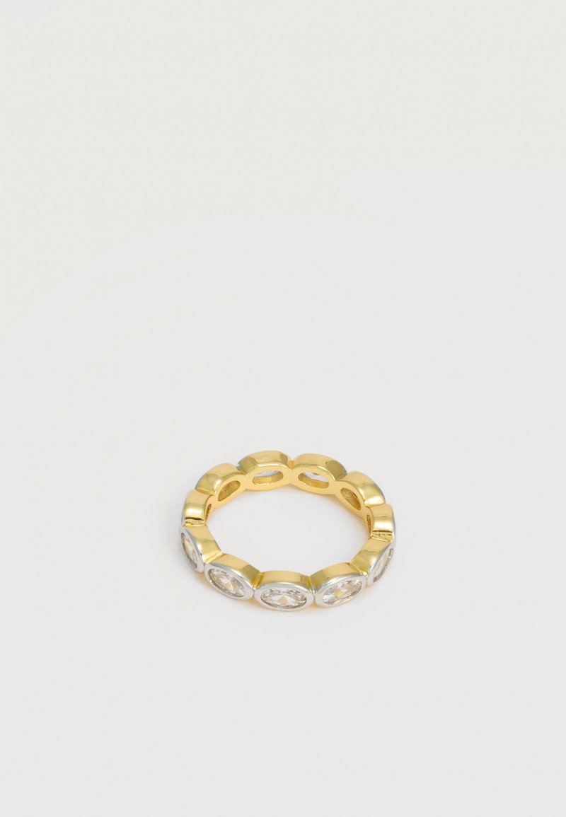 Bague en or ornée de plusieurs pierres précieuses ovales et transparentes, réparties uniformément autour de l'anneau, sur un fond clair uni.