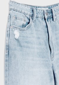 Ljusblå denimjeans med en urblekt textur, med en trasig framficka, silverdetaljer och en klassisk femficksdesign.