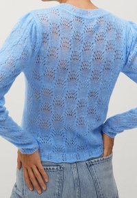 Lichtblauwe gebreide trui met een kantachtig patroon, lange mouwen en een gegolfde zoom, gemaakt van een zachte, gestructureerde garen.