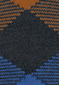 Tissu en tricot présentant un motif en zigzag brun, noir et bleu, créant un design texturé et multicolore idéal pour les vêtements.