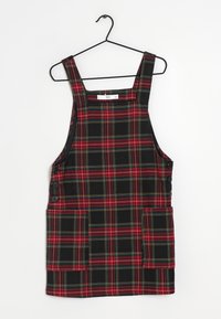 Schwarzes und rotes karierter Latzkleid mit grünen Akzenten, breiten Trägern, zwei Fronttaschen und seitlichen Knopfverschlüssen.