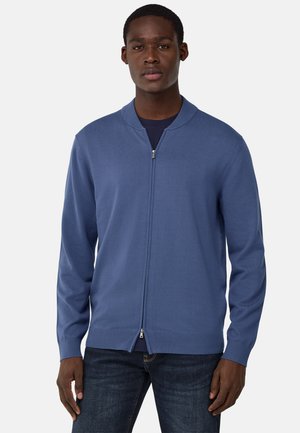 Cardigan azul claro con cremallera, hecho de un tejido de punto suave. Presenta puños y dobladillo acanalados, con un cuello redondeado que le da un diseño moderno.