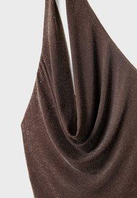 Brun draperad tygöverdel med en texturerad yta, prydd med subtila metalltrådar och en mjuk halsringning för extra detalj.