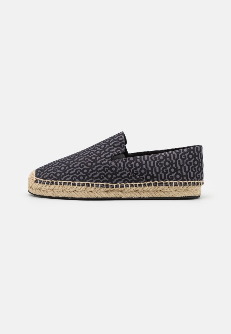 Espadrille noire à enfiler avec semelle tissée beige et motif texte répétitif "HUGO" sur toute la tige en tissu.