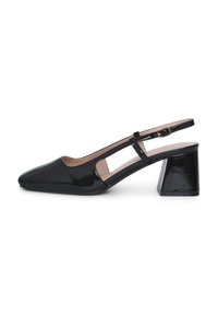 Chaussure slingback en cuir verni noir avec un bout pointu, des accents découpés et un talon moyen carré. Fermeture boucle sur la sangle.