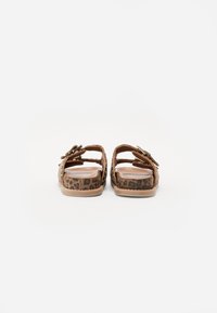 Pair of brown leopard print open-toe sandals with double buckle straps, viewed from the back against a white background.