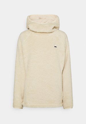 Pull en polaire couleur crème avec manches longues et col cheminée haut, avec un petit logo montagne noir sur la poitrine.