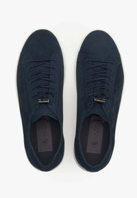 Navy zamszowe sneakersy z płaskimi sznurowadłami i srebrnym akcentem. Białe gumowe podeszwy i fakturowane wkładki z dyskretnym logo.