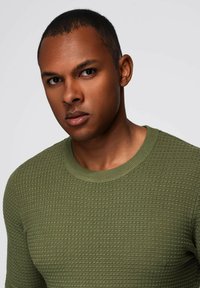 Groene gebreide trui met een textuurpatroon, ronde halslijn en geribbelde mouwen. Zachte stof met een aansluitend ontwerp, geschikt voor casual kleding.