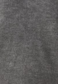 Grijze gebreide trui met een zachte textuur, geribbelde zoom, middeldikte en een eenvoudig ontwerp. Geen zichtbare patronen of accenten.