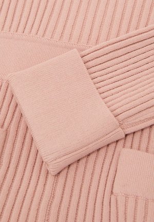 Měkká růžová žebrovaná pletenina s hladkou texturou, vybavená malou čtvercovou kapsou a žebrovanými manžetami pro přiléhavý vzhled.