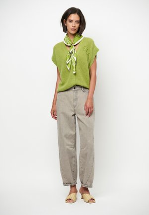 Groene gebreide korte mouwen trui met knopen aan de voorkant en geborduurde details, gecombineerd met wijde grijze spijkerbroeken en gevlochten tan schuifzolen.