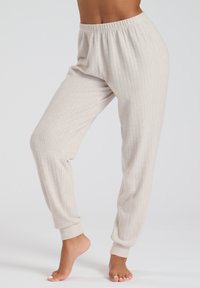 Pantalones de salón beige con canalé, con una cintura elástica y puños ajustados, que presentan una textura suave y un ajuste relajado.