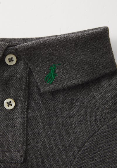 Polo gris en tissu texturé, présentant un logo vert brodé sur le col et deux boutons clairs au niveau du cou.
