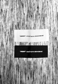 Dos etiquetas de tela: una blanca y una negra, ambas con el texto "MWM x movimiento de olas mod" en una fuente sans-serif en negrita.