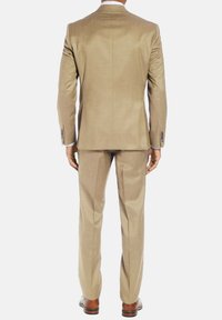 Costume beige avec une veste à simple fente et un pantalon droit. Présente une coupe ajustée, un tissu lisse et des accents de boutons contrastants.