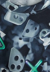Musta kangas, jossa on läpikuultavien geometristen muotojen kuvio harmaana, vihreänä ja sinisenä, mukaan lukien ympyröitä, kolmioita ja neliöitä.