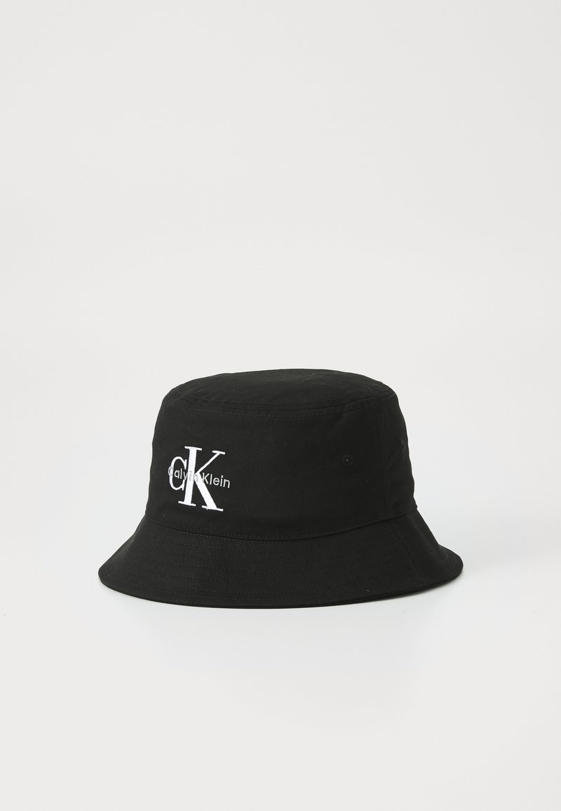 Black bucket hat made of fabric, featuring a round crown, wide floppy brim, and white embroidered "CK" logo with "calvinKlein" text.