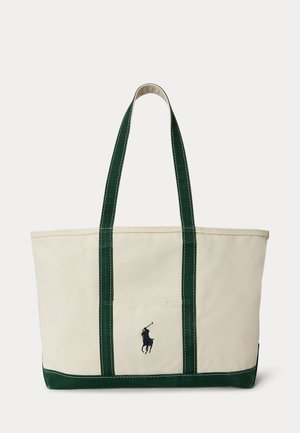 Τσάντα καμβά σε κρεμ χρώμα με σκουρό πράσινα λουριά και μπούστο, με μικρό κεντημένο λογότυπο παίκτη πόλο στην εμπρόσθια τσέπη.